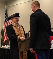 Revolutionary war re-enactor doing a ceremony with a current armed force member 