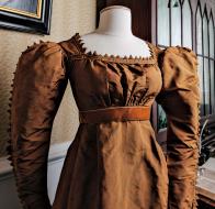 Ribbed silk taffeta dress with satin trim and modern ribbon waistband Note: Zig-zag elements were named (and misspelled) “vandykes” after Anthony Van Dyck, the Flemish portrait painter whose subjects often wore lace collars with similarly shaped edges.