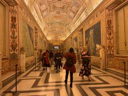 President General Wright and a group walk through the ornate halls of the Vatican.