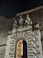 The arched entrance of the Vatican with stone statues.